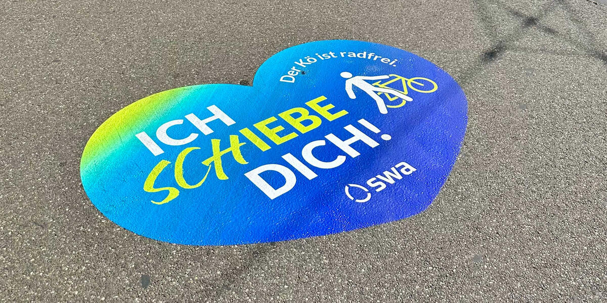 Sicher Radfahren am Königsplatz in Augsburg - Aufkleber am Boden zeigen Fahrverbot für Radler auf